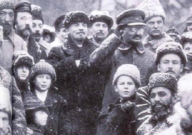 Фото: Ленин (в центре) и его соратник Троцкий (отдает честь) среди революционных солдат в Советской России зимой 1920г